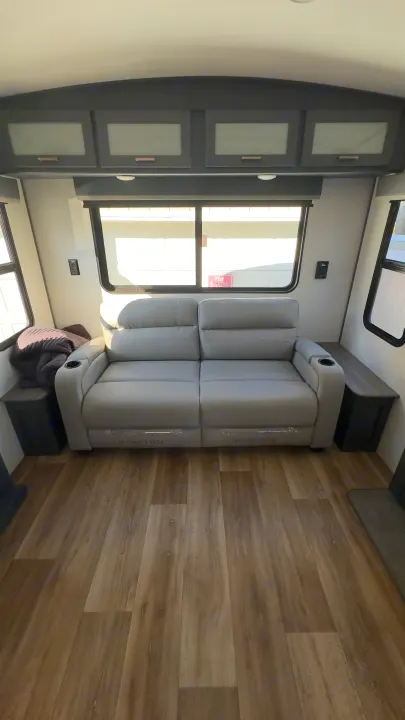 This RV rental offers a bright, modern living space with a reclining sofa, overhead storage, and large windows.. Keystone RV Bullet Premier Ultra Lite 2022