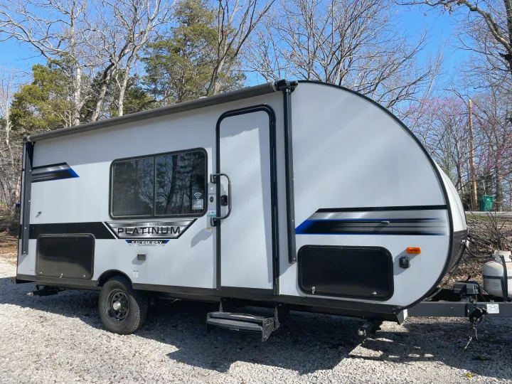 Modern grey RV rental (Platinum Salem FSX travel trailer) parked on gravel for your next camping trip.. Forest River Salem FSX PLATINUM 2021