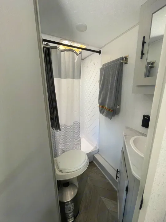 Step inside this functional RV rental bathroom, featuring a compact shower, toilet, and vanity with sink.. Forest River Salem FSX PLATINUM 2021