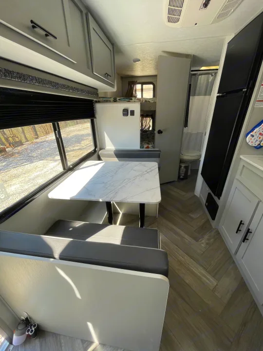 Bright RV rental interior featuring a dinette, bunk beds, and modern grey/white decor. Ideal for travel trailer trips.. Forest River Salem FSX PLATINUM 2021