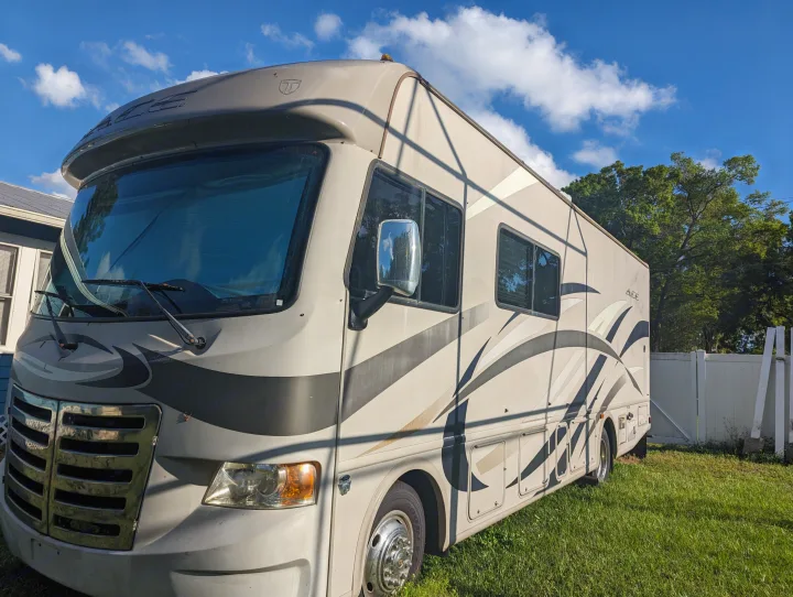 Front view of a large Thor Ace motorhome, suitable for an rv rental, parked on green grass on a sunny day.. Thor Other 2014