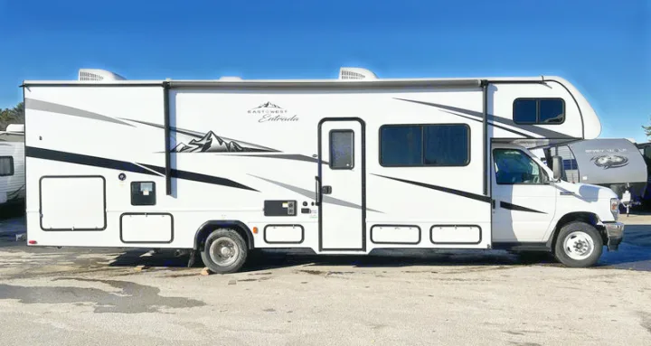 Side view of a white East to West Entrada Class C RV, parked outdoors. Ideal for your next rv rental adventure.. 1FDXE4FN9RDD14726 3100FB 2023