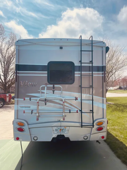 Rear view of a sleek "View" motorhome RV rental, equipped with a ladder and bike rack for adventures.. Winnebago View 2016