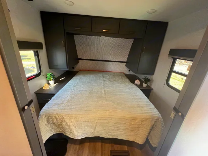 An inviting RV rental bedroom with a cozy bed, ample storage, and natural light from side windows.. Keystone Bullet Crossfire 4YDTBLN25RD430760 2024