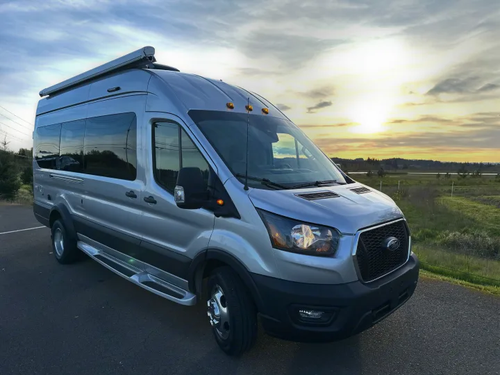 Silver Ford Transit camper van, perfect for RV rental, parked at golden hour with rural landscape.. Pleasure-Way Pleasure-Way Class B 2024