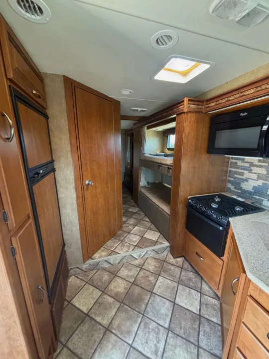 Explore this RV rental's spacious interior featuring a full kitchen with stove, microwave, fridge, and comfy bunk beds.. Forest River four winds 2016