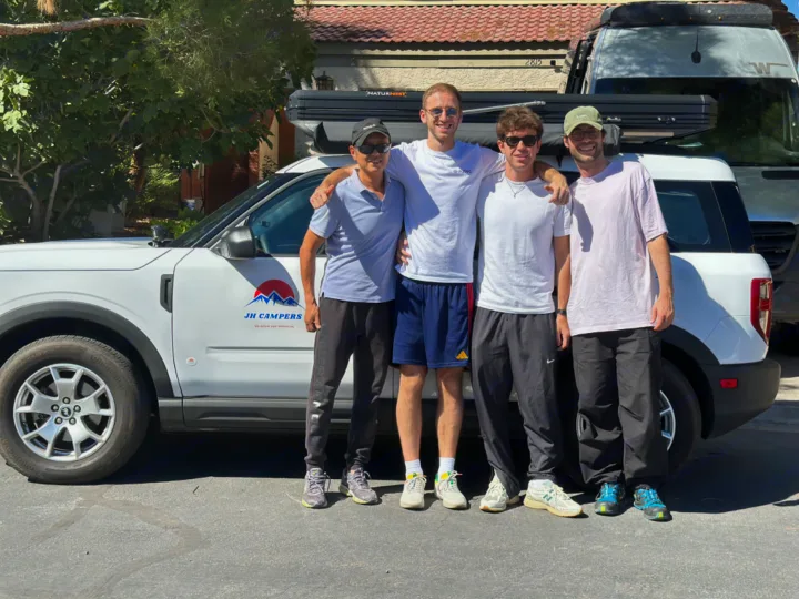 Four men with a white JH Campers RV rental SUV, featuring a NaturNest roof-top tent.. Ford Bronco Sport 2022