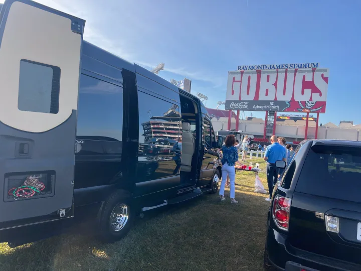 Tailgating at Raymond James Stadium with an RV rental before a Bucs game. People gather, enjoying the atmosphere.. Mercedes-Benz Sprinter 2024