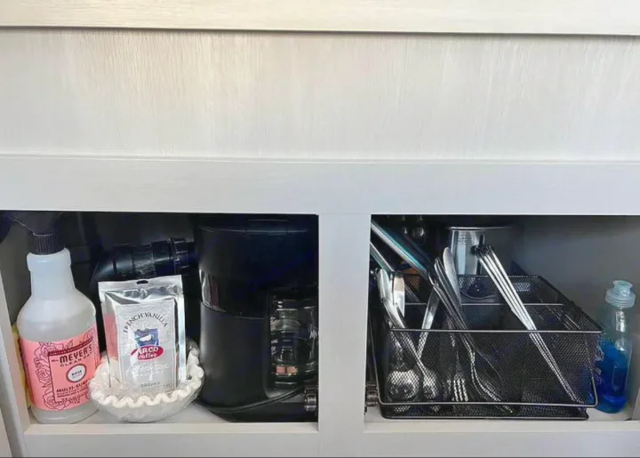 RV rental kitchen cabinet: Organized coffee, cleaning supplies, and utensils for a tidy setup.. Forest River Wildwood FSX Plantium 2022