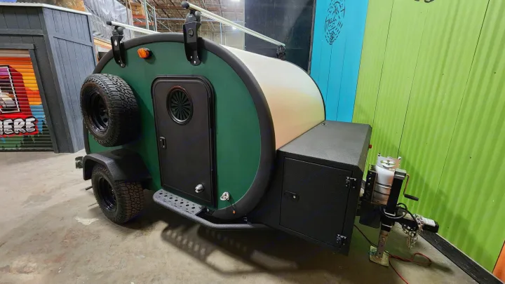 Explore with this rugged green teardrop camper, an ideal RV rental for outdoor adventures & travel. Spare tire & roof rack.. Bean Trailer Bean Trailer Trailer 2024