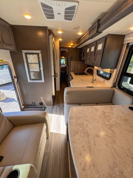 Spacious RV rental interior featuring a modern kitchen, dining area, and comfortable lounge seating.. Thor Motor Coach Pasadena  Super-C 2023