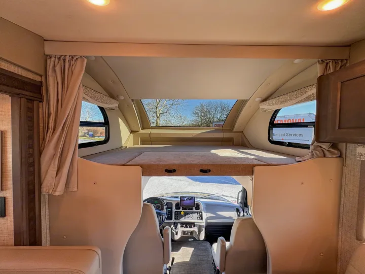 This RV rental offers a spacious interior, featuring an overhead bunk and the motorhome's driver cockpit.. Thor Motor Coach Pasadena  Super-C 2023