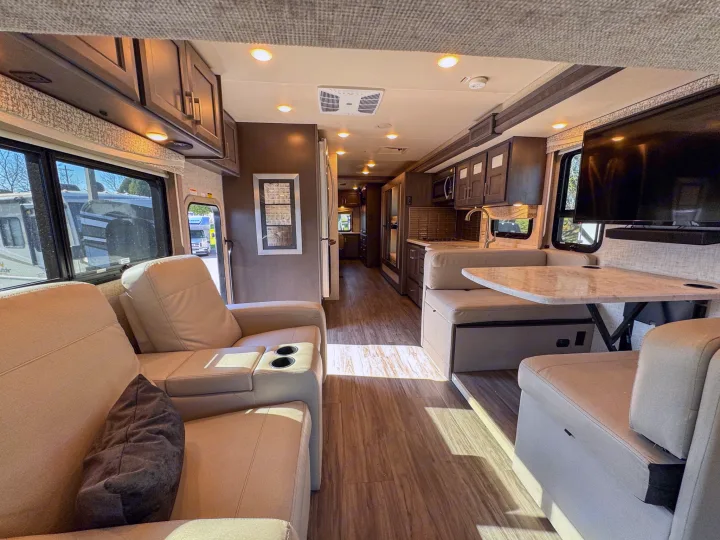 Well-lit, modern RV interior for your rv rental adventure. Features sofa, dinette, kitchen, and TV.. Thor Motor Coach Pasadena  Super-C 2023