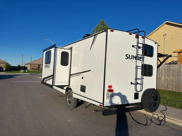 Modern white RV rental, a travel trailer with an extended slide, ready for your next adventure.. Crossroads RV Sunset Trail Super Lite 2022