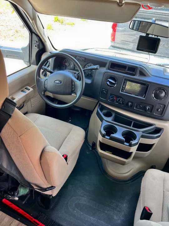 Inside an RV rental: driver's cockpit view with Ford steering wheel, dashboard, multimedia screen, and cup holders.. Forester GTS 2018