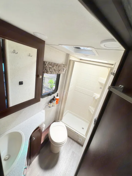 This RV rental's compact bathroom features a vanity with sink, a toilet, and a stand-up shower stall.. Forester GTS 2018