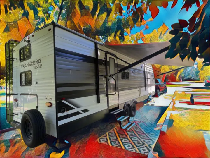 RV rental: Spacious travel trailer with extended awning and outdoor rug at a colorful campsite.. Grand Design Transcend Xplor 265BH 2022