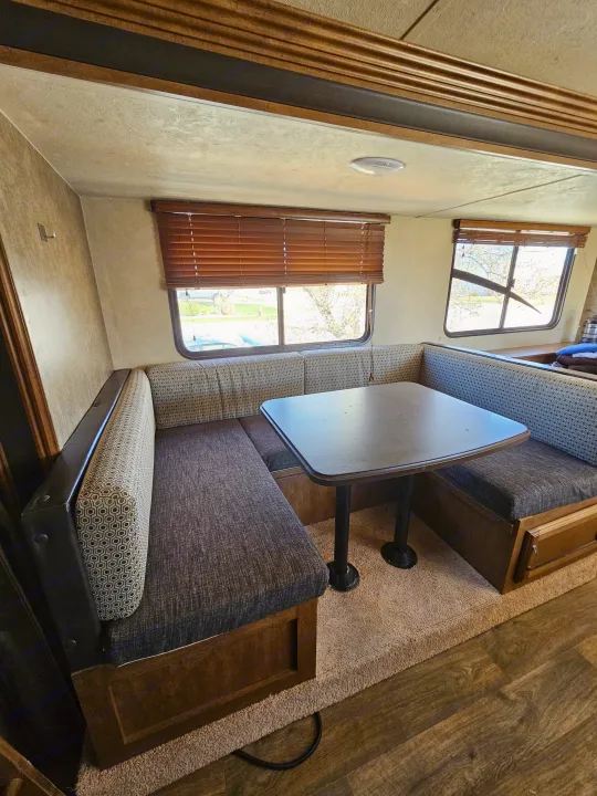 Experience comfort in this RV rental dinette, featuring U-shaped bench seating, a table, and large windows.. Forest River Salem Cruise Lite 2017