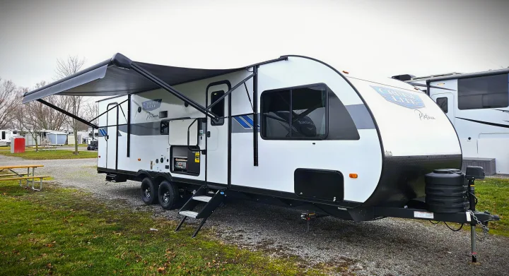 White Cruise Lite Platinum travel trailer with extended awning for RV rental. Parked in a gravel lot.. Forest River Salem Cruise Lite Platinum 2024