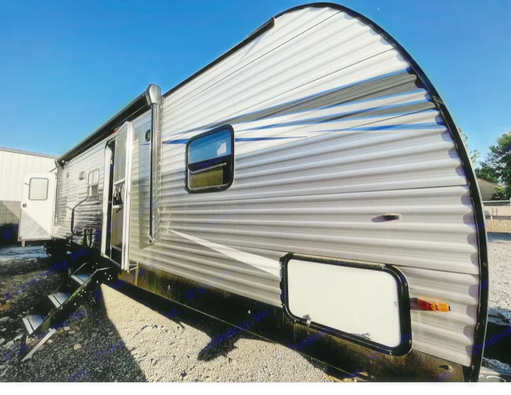Sleek gray RV rental travel trailer with blue accents, open door, and steps, perfect for your next outdoor adventure.. Forest River PRIME TIME AVENGER 2021