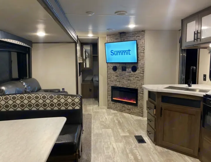 Spacious RV rental interior featuring a modern kitchen, cozy fireplace, dinette, and living area. Perfect for your next adventure.. Forest River PRIME TIME AVENGER 2021