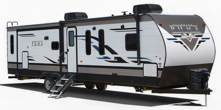 Palomino Puma travel trailer, a spacious white and grey RV rental with a visible slide-out and awning arm.. Forest River Puma 2023