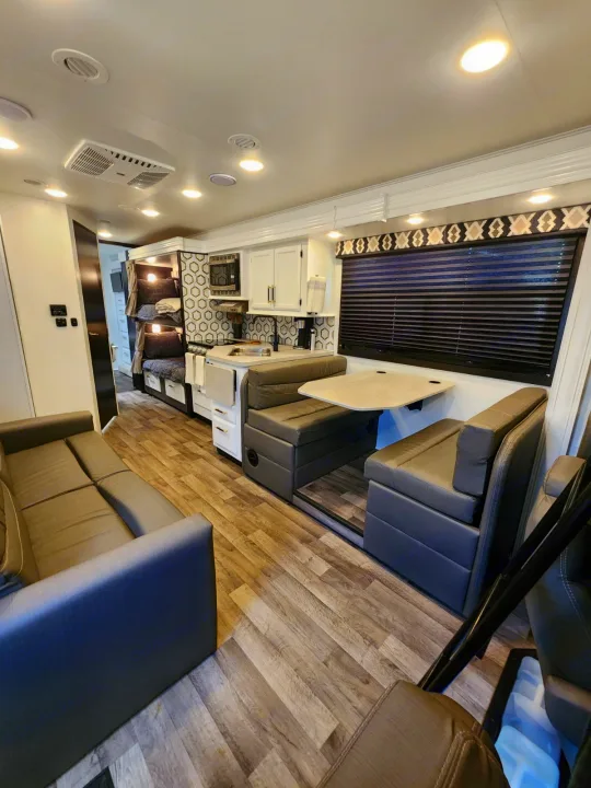 Explore this RV rental's spacious interior: modern kitchen, comfortable dinette, and cozy bunk beds. Perfect for travel adventures.. Entegra Coach Odyssey 2021