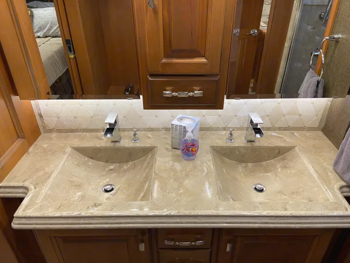 Spacious RV rental bathroom featuring a modern double vanity with stone sinks, chrome faucets, and ample counter space for comfortable travel.. Tiffin Motorhomes Allegro Bus 2017