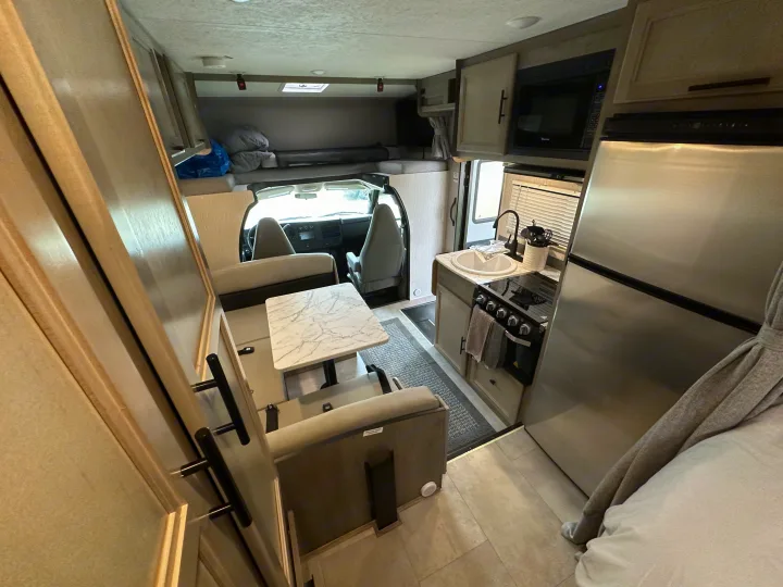 This rv rental features a well-equipped kitchen, dining area, and a bed over the cab, offering all comforts for your trip.. Coachmen Other 2022