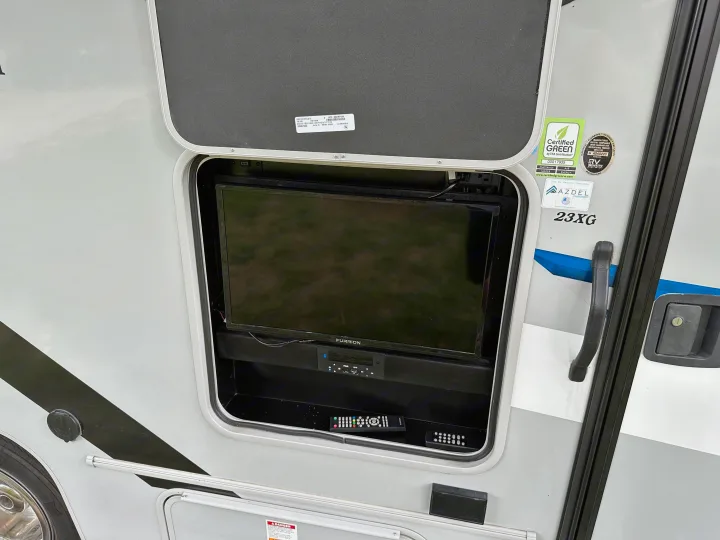 Exterior entertainment compartment on an RV rental, featuring a Furrion TV and soundbar with remotes, ideal for outdoor viewing.. Coachmen Other 2022