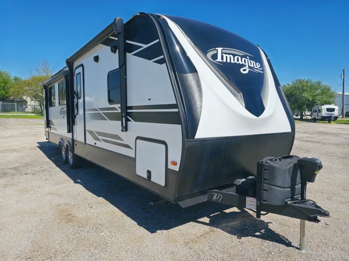Pristine white and black Imagine travel trailer on a sunny day. Ideal for outdoor adventures and your next RV rental getaway.. Grand Design Imagine 2021