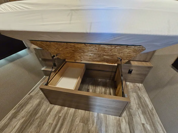 RV rental: Lift-up bed reveals spacious under-bed storage with a pull-out bin, ideal for travel.. Grand Design Imagine 2021