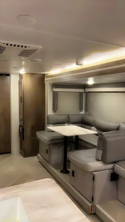 This RV rental interior features a modern U-shaped dinette and living area with a visible ceiling stain. Comfortable for travel.. Forest River Wildwood X-Lite 2021