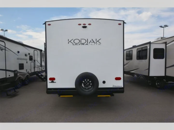 Rear view of a white Kodiak Ultra-Lite travel trailer with a mounted spare tire. An ideal RV rental for your next adventure.. Keystone Kodiak 2022