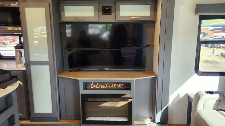 RV rental: Modern living space with TV, electric fireplace, storage, and a window view of the campground.. Keystone RV Bullet Premier Ultra Lite 2022