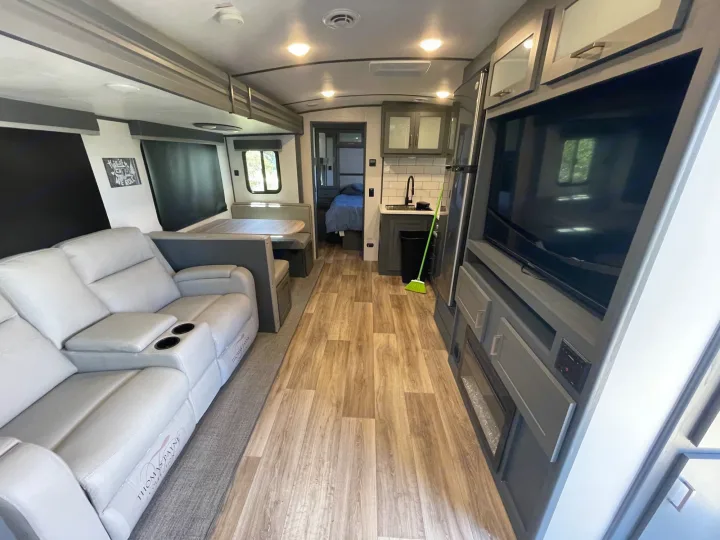 Bright, spacious RV rental interior: living area with recliners, kitchen, dinette, and bedroom visible. Ready for adventure!. Keystone RV Bullet Premier Ultra Lite 2022