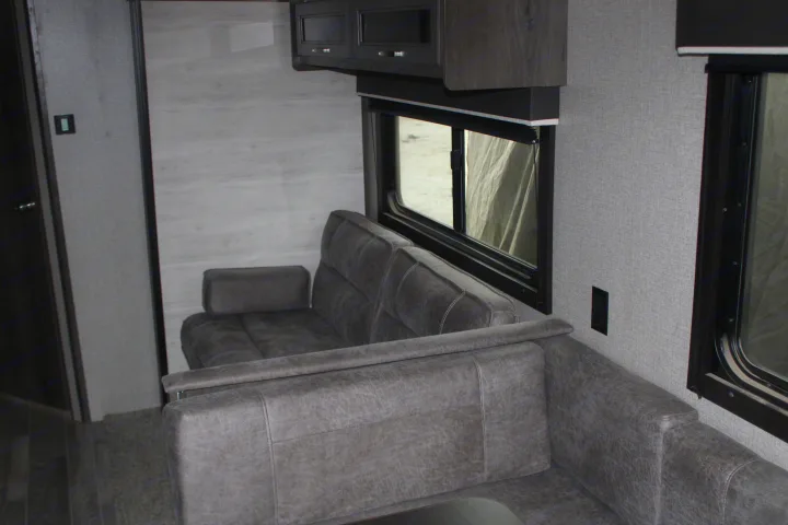 Cozy RV rental interior with gray sofa, large window, and overhead cabinets. Perfect for your next trip!. Jayco Jayflight SLX 8 2021