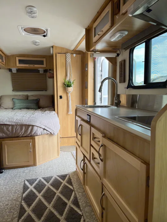 Explore this modern RV rental interior: compact kitchen, cozy bed, and clever storage solutions for your travels.. Escape Trailer Escape Trailer Trailer 2022