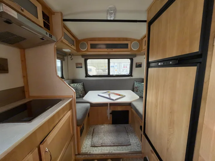 Inside this cozy RV rental: a modern kitchen, comfortable dinette, and large fridge, ready for your adventures.. Escape Trailer Escape Trailer Trailer 2022