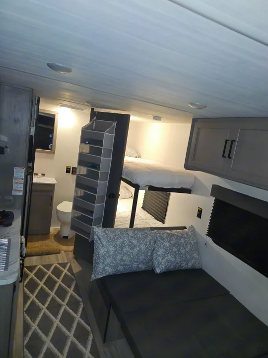 Compact RV rental interior: Features bunk beds, a small kitchen, and bathroom, maximizing functional living space.. Keystone RV Keystone Hideout 175BH 2024