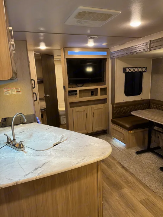 Discover this inviting RV rental interior: modern kitchen, cozy dinette, TV, and bunk beds.. Coachmen Freedom Express 2020