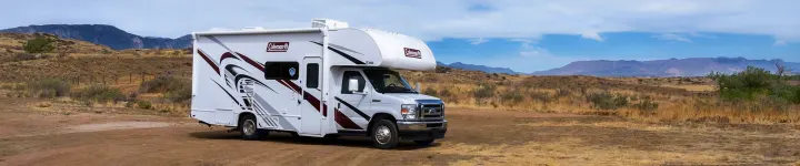 White Coleman RV rental parked in a dry, mountainous landscape, ready for adventure.. Thor Coleman 2023