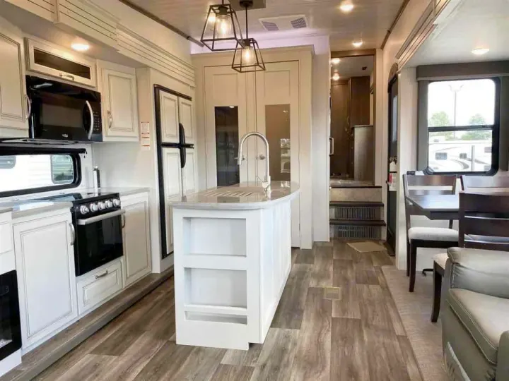 Modern RV rental kitchen & living space with island, dining area, and full appliances.. Keystone Cougar 2022