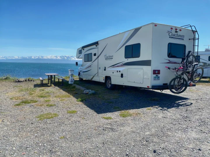 Experience a stunning rv rental adventure! Coachmen RV by serene waters, snow-capped mountains. A perfect travel campsite view.. Forest River Coachmen Freelander 2015