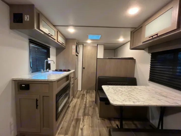 Spacious RV rental interior featuring a modern kitchen, cozy dinette, and convenient bunk beds.. Coleman Lantern LT 17 B 2024