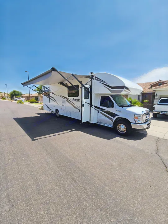 This Jayco RV rental is ready for your next adventure, parked with its awning out on a sunny day.. Jayco Redhawk 2020