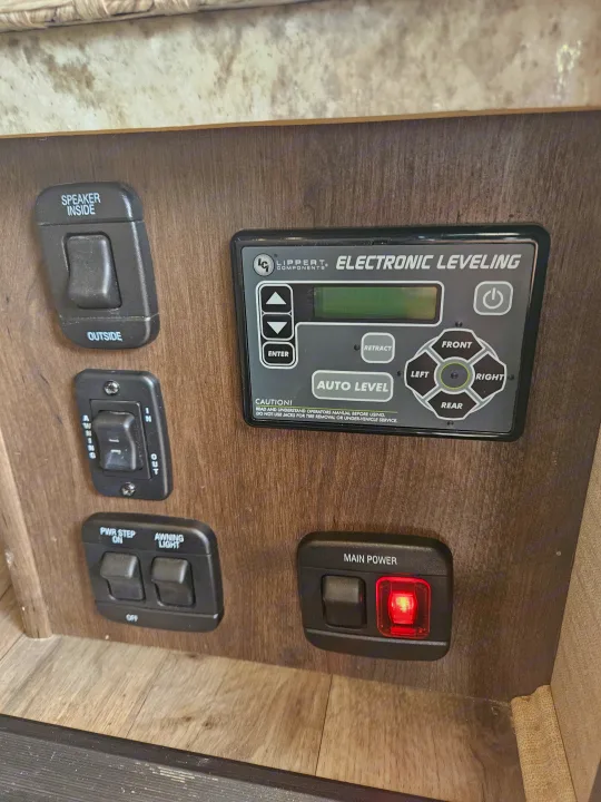RV rental control panel shows electronic leveling system, speaker, awning, power step, and main power switches.. Jayco Redhawk 2020