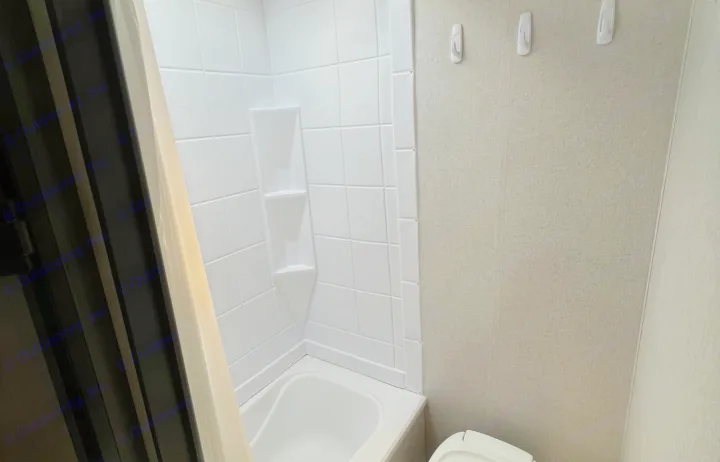 Compact RV rental bathroom features a small tub/shower, textured walls, and a toilet, perfect for road trips.. Clipper Ultra Lite 2022