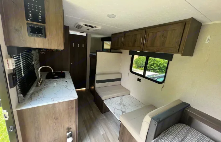 Inside this **rv rental**: a functional kitchen with sink, controls, and a comfortable dinette. Bright, modern interior for your trip.. Clipper Ultra Lite 2022
