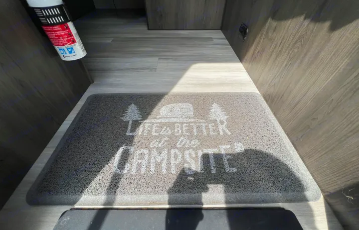 Inside an RV rental, a doormat with "LIFE IS BETTER at the CAMPSITE" text is visible, near a fire extinguisher.. Clipper Ultra Lite 2022
